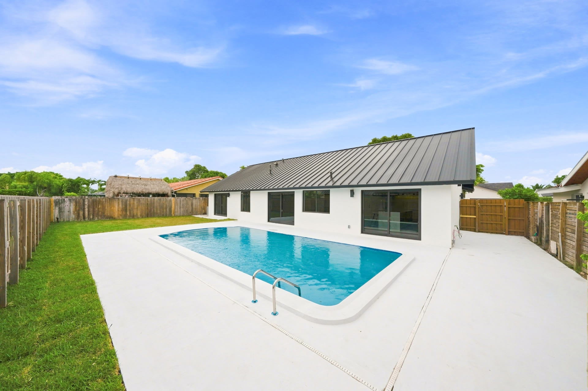 Calusa home with a swimming pool, sunlit patio and fenced backyard